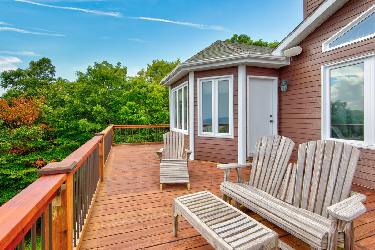 A wooden deck with lounge chairs offers a tranquil spot surrounded by lush greenery. The setup invites relaxation, morning coffee, or evening stargazing, reflecting the section's emphasis on quality family time outdoors after days spent exploring Boone's attractions.